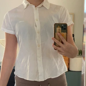 Tajt kortärmad skjorta - En vit kortärmad skjorta. Inga tydliga slitage. Finns missfärgning vid kragen innanför. 