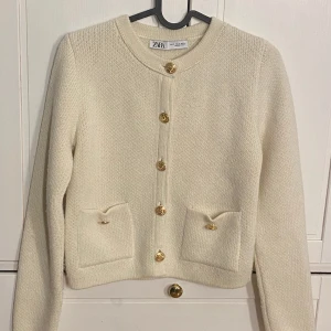 Jättefin cardigan från zara - Denna jättefina krämvita cardigan med guldknappar från zara, säljer jag för att den inte kommer till användning. Den är använd 1 gång så helt i nyskick! Inga fläckar eller defekter! Ny pris 499kr Den är S men passar perfekt för mig som oftast har xs💕