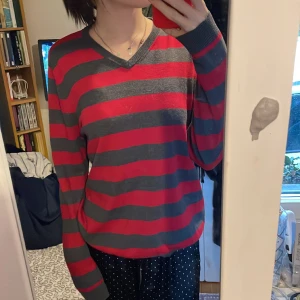 Grå/röd randig tröja  - Jag säljer denna tröja, den är i toppen skick. Jag har ej använt tröjan så många gånger men den ör super fin. 