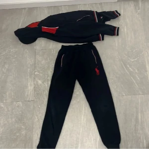 Polo ralph lauren tracksuit - En polo ralph lauren tracksuit som jag säljer eftersom jag har växt ur den för ett långt tag sedan. Den är i bra skick, men har inga ”skador”. Kofta: 150kr. Byxa: 150kr. Båda två 250kr. OSÄKER på storleken! Hör av dig om det är något!