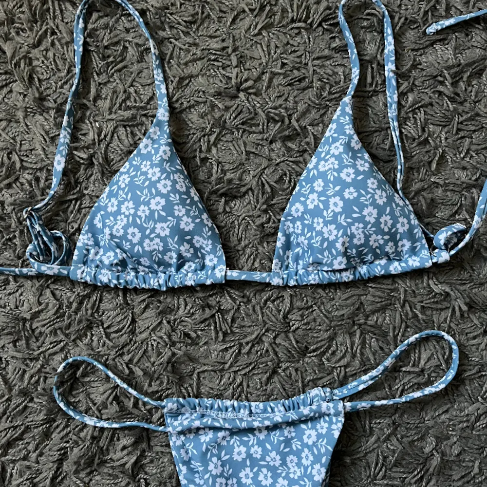 Helt oanvänd, blå blommig bikini i storlek XS.  80 kr, hämtas i Kalmar eller skickas mot fraktkostnad.. Övrigt.