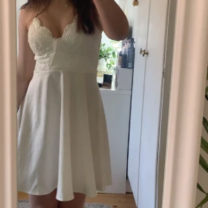 Konfirmations/student klänning - Jättegullig konfirmation eller student klänning i vit, inbyggd bh. Köpt här på plick och bara använd 1 gång av mig. Korsade band i ryggen så axelbanden åker inte ner. Stl 34 passar både xs och s 