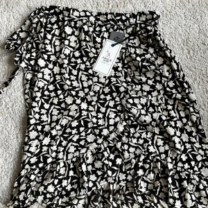 Omlottkjol - Superfin omlottkjol med blommigt mönster och knytdetalj i sidan. Aldrig använd. Säljer pga för liten för mig. Köpt på Ullared. Storlek XS. (Lite längre modell men fortfarande över knäna). Tveka inte att höra av dig om du har frågor