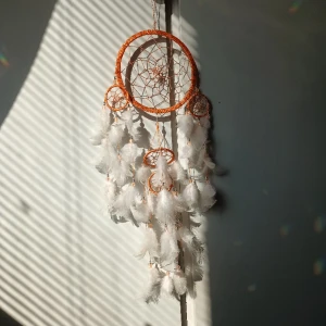 Rosa orange drömfångare - 🩷FÖRST TILL KVARN!🩷 En drömmig drömfångare med ljusrosa fjädrar och orange ram, har även pärlor vid varje fjäder. Har hängt på mitt fönster som dekoration men har flyttat och vill nu inreda om.