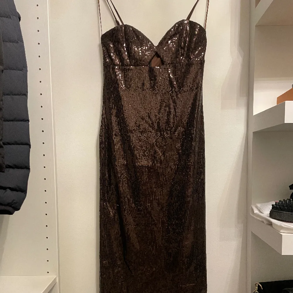Säljer denna bruna långa paljettklänningen då den baga legat i min låda tills nu. Aldrig använd🤍. Klänningar.