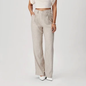 Adoore kostymbyxor  - Högmidjade kostymbyxor från Adoore. Strl 40. Något noppriga i skrevet samt en lös söm längst ner på ena byxbenet - går enkelt att sy upp.