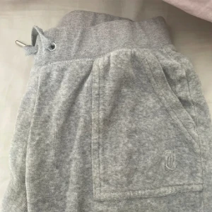 Gråa juicy byxor  - Säljer dessa gråa juicy byxor då jag ej använder de längre. Dom är i bra skick men bara att ena märket på ena snöret lossnat, därav lågt pris. Jag är ca 166 och de passar i längden. Skriv gärna privat innan nu trycker på köp nu❤️  Sänkt pris 💓