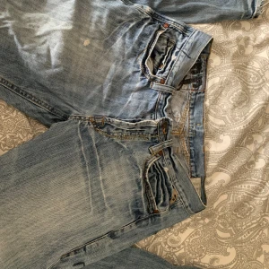 Blåa jeans - Jättecoola jeans som tyvärr är för stora på mig. De är lite slitna längst ner men annars i bra skick. Midjemått: 43 cm, längd: 106 cm