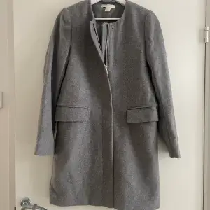 En väldigt fin kappa i ull ifrån H&M i  stl 34 väldigt fint skick pga sparsamt använd. 