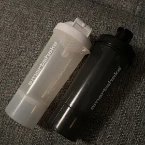 Shakers från smartshake med plats för förvaring under shaken tex för proteinpulver eller mediciner. Svart och vit 