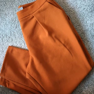 Orangea "kostymbyxor"  - Noppriga eftersom de har använts men annars inga andra skavanker.   Petite vilket betyder att dem är för korta personer. Är själv 161.