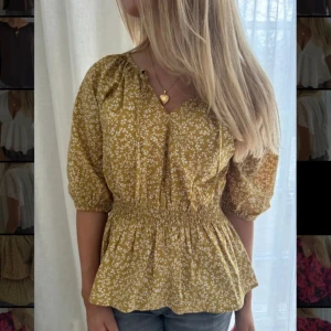 Blus - Väldigt fin blus som är gul med vita blommor. Smock i midjan. Ny. Ord pris 399kr, mitt pris 129kr