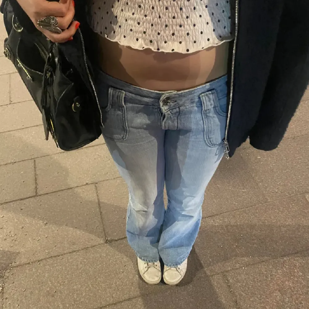 Säljer dessa superfina ljusblåa lågmidjade jeans med gulliga fickor❣️Byxorna passar mig i längden som är ca 165 cm ( med lite längre ben). Obs dock att de har en del slitage i änden på benen vilket du kan se på bild 4, annars super fina❤️. Jeans & Byxor.