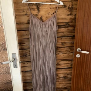 Klänning - Snygg klänning med spetskant och justerbara spaghettiband. Aldrig använd. Stl M. Mörkbeige 