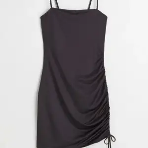 En svart bodycon klänning med spagetti straps och en dragsko vid ena låret. Perfekt för fest eller till sommaren. Oanvänd men saknar prislapp. 💗🤩