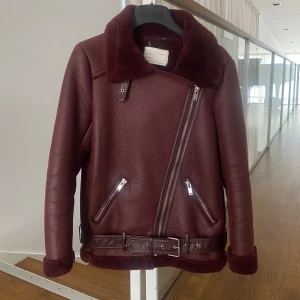Bikerjacka Zara - Vinröd bikerjacka från Zara i storlek xs! Bra skick utan defekter, förutom att sömmar för banden som håller midjeskärpet har lossnat innan (men är väl lagat nu och syns ej)! 