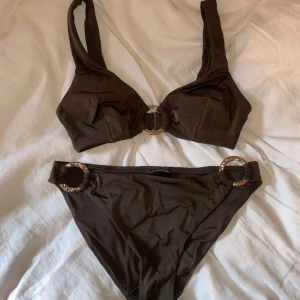 Bikini från hm - Mörkbrun bikini med guldiga detaljer. Aldrig använd.💕