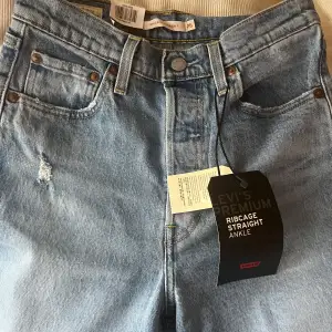 Helt oanvända jeans från Levi’s i storlek 26x27. Jättefina på men ej blivit använda. Hög midja, croppade ben och reva på ena knät.