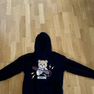 Moschino hoodie  - Hej säljer min Moschino hoodie då den är för liten, har använts några gånger. Skick 9/10, passar bra på dom som är 160-170cm långa.