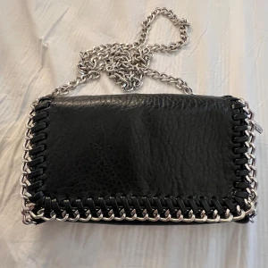 Väska - Jättefin tiamo väska i svart. Den är använd men har inga defekter förutom att ena knappen är lite trasig men den funkar fortfarande som vanligt. Nypris 500kr. Skriv för mer bilder💕