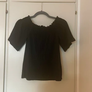 Svart sommartopp  - Lite stor i storleken och medeltunt material. Armarna är lite breda och perfekt en sommardag. Har används endast en gång så är i mycket bra skick.