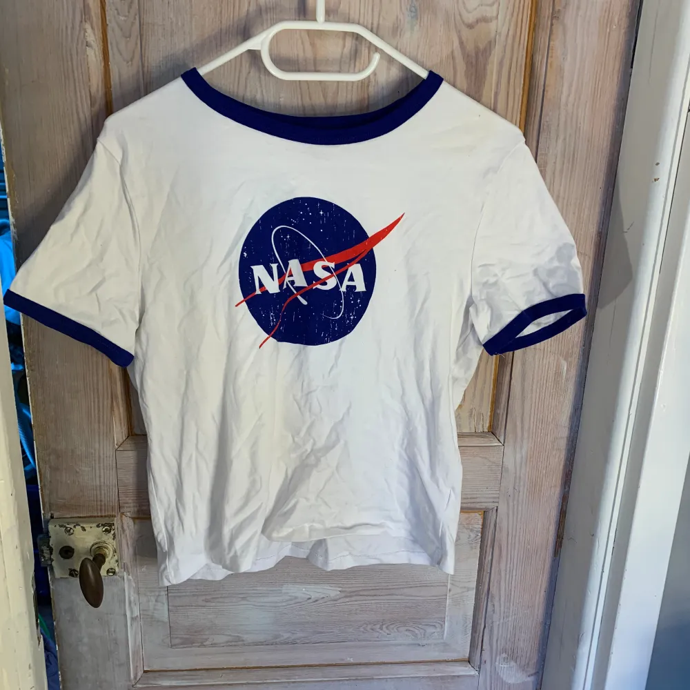 En vit NASA - tröja som är en lite längre magtröja. Endast använd 1 gång. Utmärkt skick!. T-shirts.