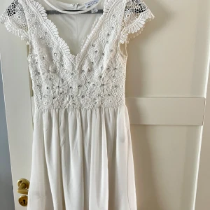 Vit klänning med diamanter - Vit klänning med stenar på. Väldigt gott skick, använd endast en gång. 