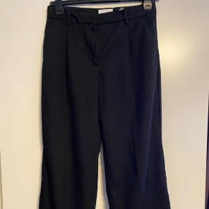 Kostymbyxor strl 40, short - Vida ben. OBS! Dessa byxor är uppsydda och passar dig som är ca 155-160cm. Kolla sista bild för benlängd från grenen.  Dessa sömmar går dock att sprätta och då är byxan full längd.  Kolla in mina övriga annonser för samfrakt.