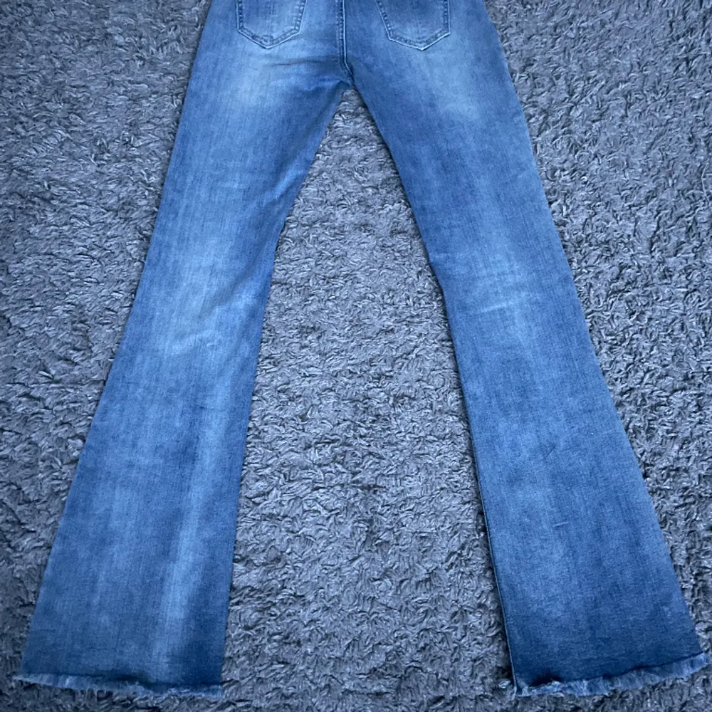 Lågmidjade bootcut jeans med detaljer  Midjemåttet 35  Innerbenslängd 81  Ytterbenslängd 104. Jeans & Byxor.