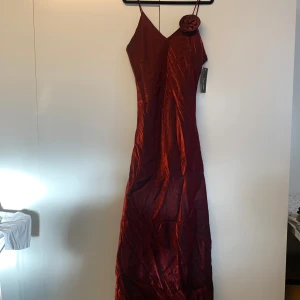 Vinröd aftonklänning - Vinröd aftonklänning i skönt material, aldrig kommit till användning därav lappen. Materialet är viskos och polyester, den passar någon som är 170/175💗