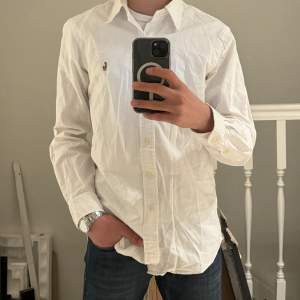 Slim Fit Shirt Oxford White. Plagget är i nyskick och har inga defekter. Skicka prisförslag så kan vi diskutera. Skjortan finns på Care of Carl för 1600kr nypris. Killen på bilden är 170cm och skjortan sitter bra men lite stor.