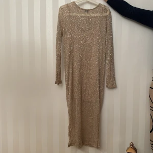 Kläder  - En klänning från Ginatricot i storlek L.Den har bara kommit till användning 1 gång under nyår och är i ganska bra skick.Armarna har en liten slits längst ut i armarna och den är ungefär under knäna.Pris kan diskuteras.💫