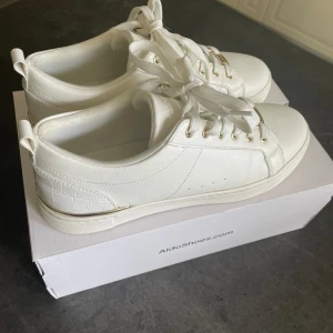 Vita sneakers  - Säljer dessa supersnygga sneakers från Aldo med guld detaljer som tyvärr var för små för mig. Köpta på Zalando för 729kr. Storlek 40 men dem är små så passar 38/39💘