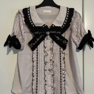 Liz Lisa blus - Liz Lisa blus från deras sommar kollektion 2023. Säljer då den inte sitter bra på mig, endast  använd två gånger så i nyskick.  Rosetten är avtagbar.  Byst: 98 cm  Ärmvidd: 29cm  Axelbredd: 33cm 