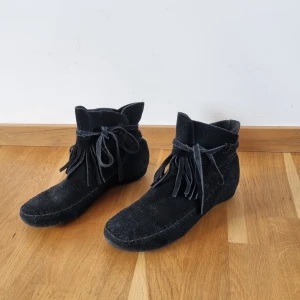 Skor med fransar - Söta skor med fransar. Storlek 41, innermått ca 26,5 cm. Inköpta i New York, osäker på märke men står GC. Små tecken på användning, men fint skick. Snöre att knyta runt, men det ena har gått av och är lite kortare.  Vet ej om fuskmocka eller äkta.