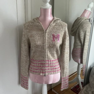 Stickad kofta - Stickad kofta med ett M i paljetter och rosa ränder på muddarna🤎🩷