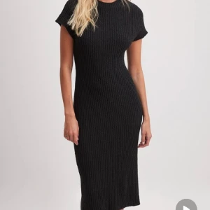 Ribbstickad klänning  - Svart Ribbstickad klänning i storlek XSS. Sitter otroligt fint på kroppen. Aldrig använd. Slut såld på NA-KD. 