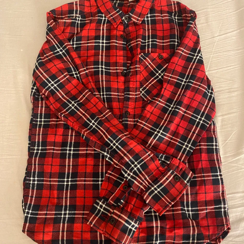 Säljer denna snygga röda skjortan från H&M då den inte är min stil längre. Inte används mycket så är i bra skick! Har en ficka på bysten på höger sida. OBS! Tvättar alltid plaggen innan jag skickar iväg dom.. Skjortor.