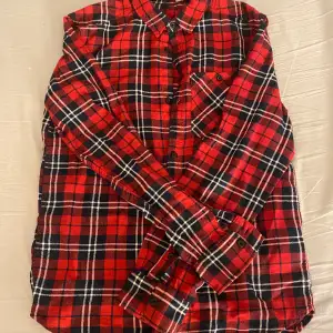 Säljer denna snygga röda skjortan från H&M då den inte är min stil längre. Inte används mycket så är i bra skick! Har en ficka på bysten på höger sida. OBS! Tvättar alltid plaggen innan jag skickar iväg dom.