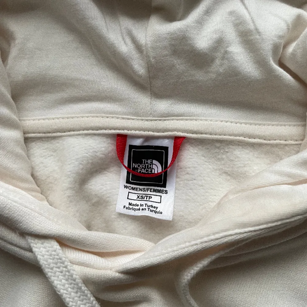 Vit hoodie med tryck på fram och baksida  Använd en gång och säljer pågrund av förliten storlek . Hoodies.