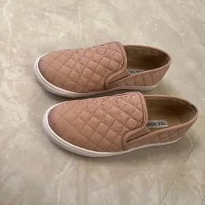 Steve Madden sneakers - Slip-On sneakers från Steve Madden i quiltat tyg. Gammalrosa färg. Strl 38,5 Endast använda ett fåtal gånger, säljes pga för liten strl.