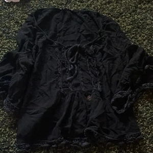 Svart blu - Fin, passar alla stilar och plagg. Somrig men samtidigt ganska mysig att ta på sig under hösten/vintern/våren. Kommer i gott skick. Har endast använt den 2-3 gånger. För er som har en lång överkropp kan denna blusen bilda en slags magtröja :) 