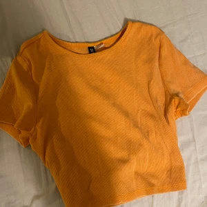Croppad T-shirt  - En Croppad T-shirt från hm divided. Säljer då jag inte använder den, använd typ en gång, nyskick. Nypris 50kr. Hör av dig vid frågor!