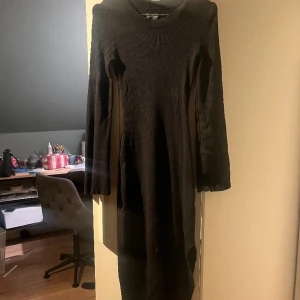 Svart klänning - Svart långärmadklänning med vida armar, ribbad och i ett väldigt stretchigt material, använd ett fåtal gånger