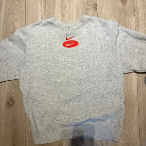 Nike tröja  - Tröjan är i mycket bra skick och är använd fåtal gånger. Den är grå melerad med röda detaljer. 