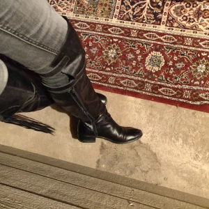 Novita stövlar knähöga boots 38 fransar fringes metal rocker hårdrock skinn - Säljer ett par dundersnygga stövlar från Novita i äkta skinn. Väldigt bekväma att gå i. Kan "stylas ner" om man vill, fransarna kan gömmas samt skaftet kan vikas ner. Varför man nu skulle vilja göra det.. fint skick! Finns inte att få ta på i butik. 