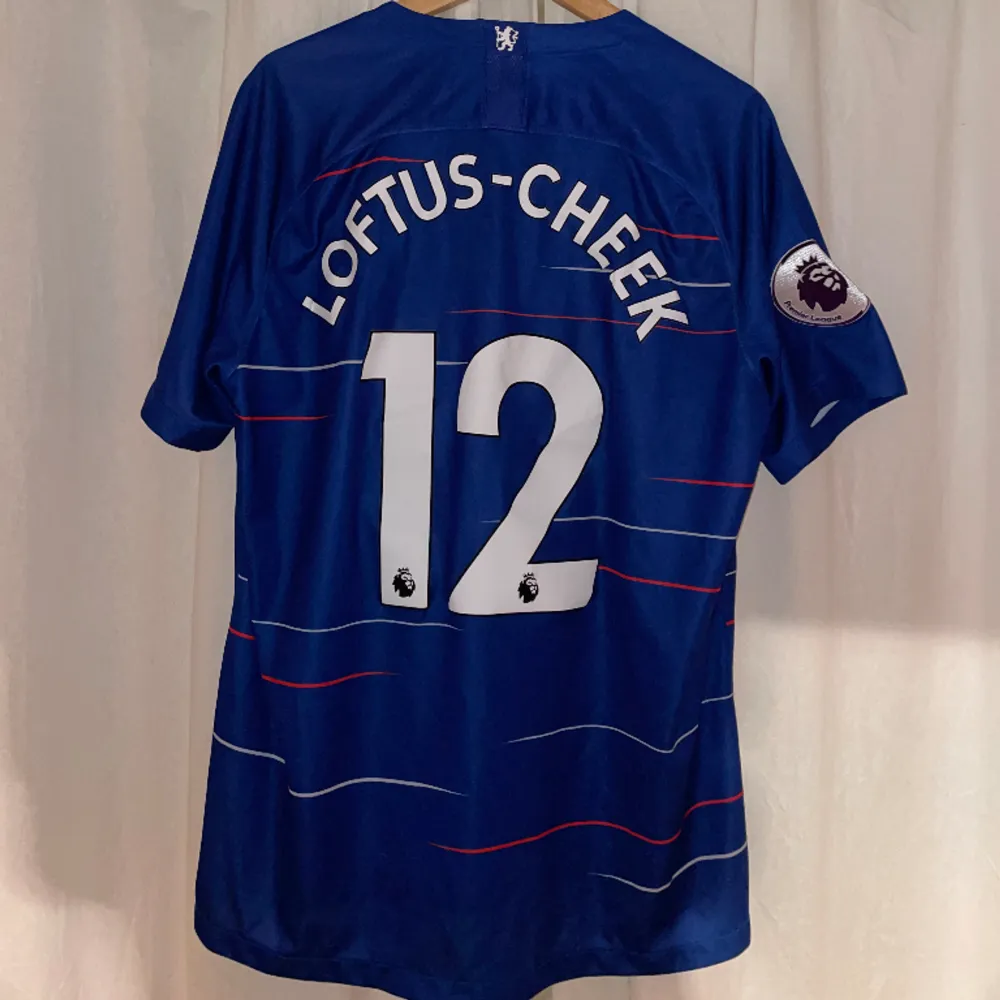Officiel Chelseatröja från 2018 med Loftus Cheek #12 på ryggen. Vissa bokstäver har tappat lite smått i fästes annars i toppskick. T-shirts.