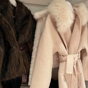 Beige päls kappa - Jag säljer en ljus beige kappa i storlek XS köpt på Ssshop.se för 3700kr. Den är super fin med ett litet slitt på vardera sida med en stor luva och en vacker päls. Aldrig använd men utan prislapp. OVERSIZE så passar S/M också(SOM NY)) ❤️❤️