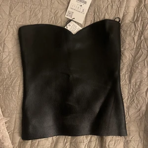 Läder tubtopp - Säljer denna tubtopp som är trendig just nu. Aldrig använt då den är för liten. Prislappen står kvar. Köpt för 350kr. 
