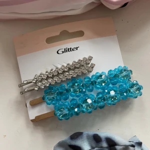 Hårspännen - Glittriga hårspännen med stenar och hårspännen med blå pärlor. Från Glitter. Aldrig använda, 5kr per par. Bara att fråga om det är något du undrar! Kan mötas på Järntorget i Göteborg eller skicka, köparen står för frakt.
